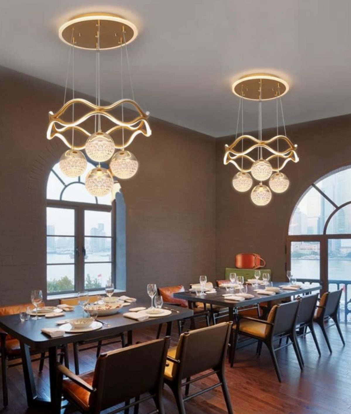 Modern dining room with gold pendant lights and large windows.