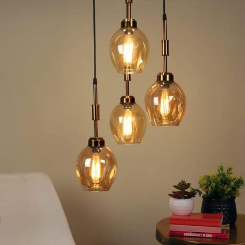 Three amber glass pendant lights hanging against a neutral background.