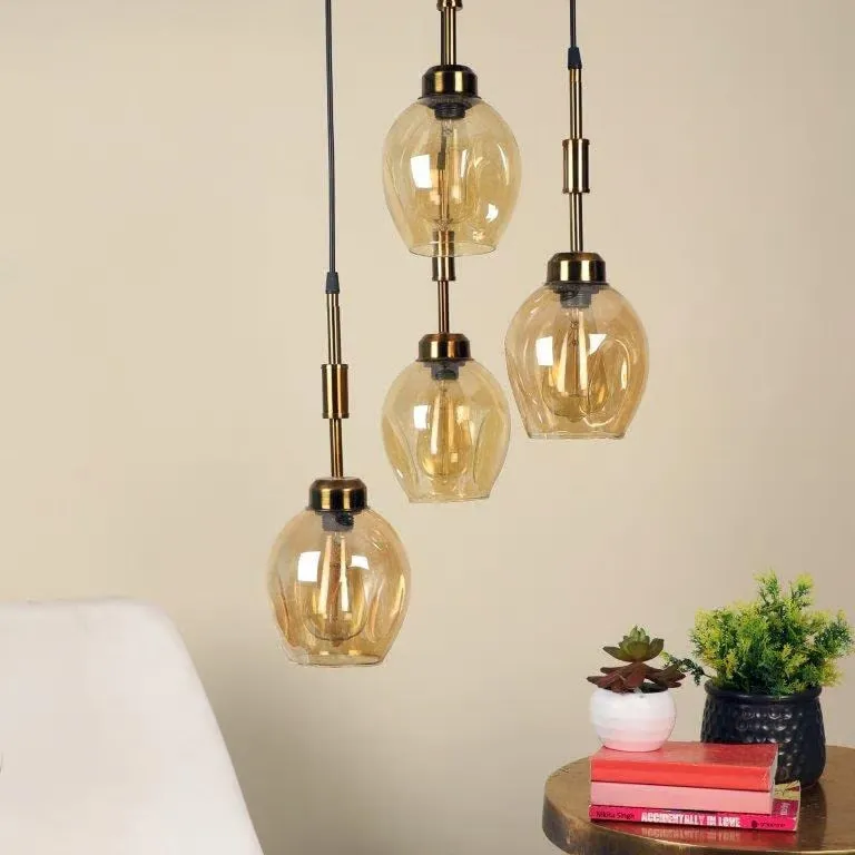 Set of glass pendant lights with gold accents on a neutral background