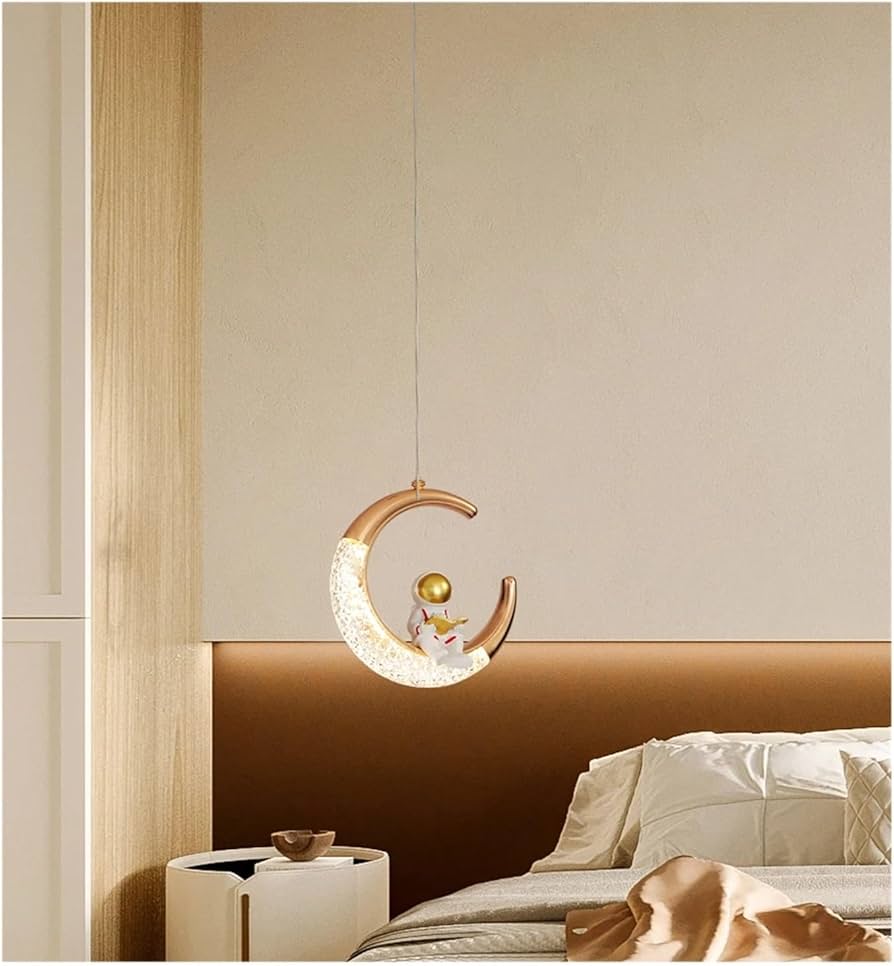 Decorative pendant light shaped like a crescent moon with a gold border in a bedroom setting.