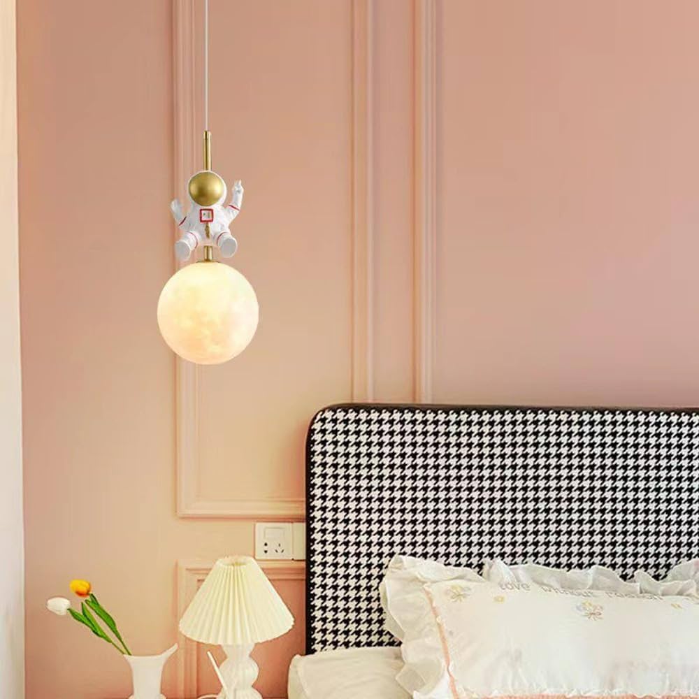 Decorative pendant light fixture in a bedroom with a pink wall and black and white headboard.