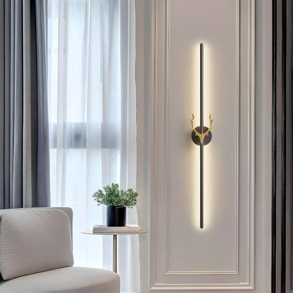 Modern wall sconce with decorative design on a wall next to a window with curtains.