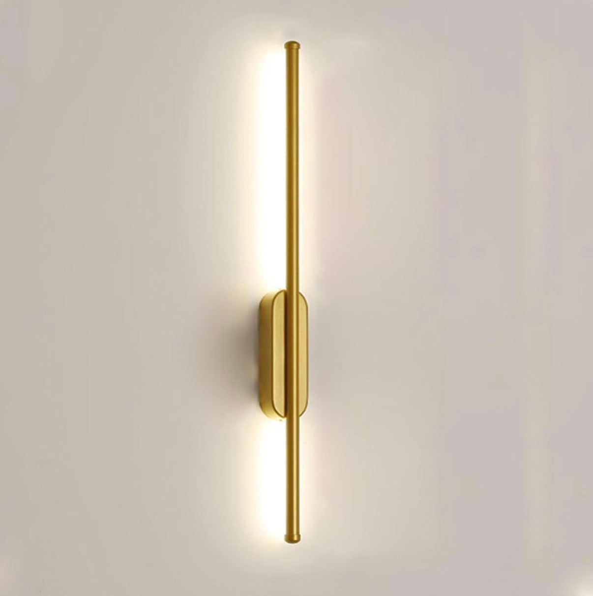 Gold wall-mounted light fixture on a white wall