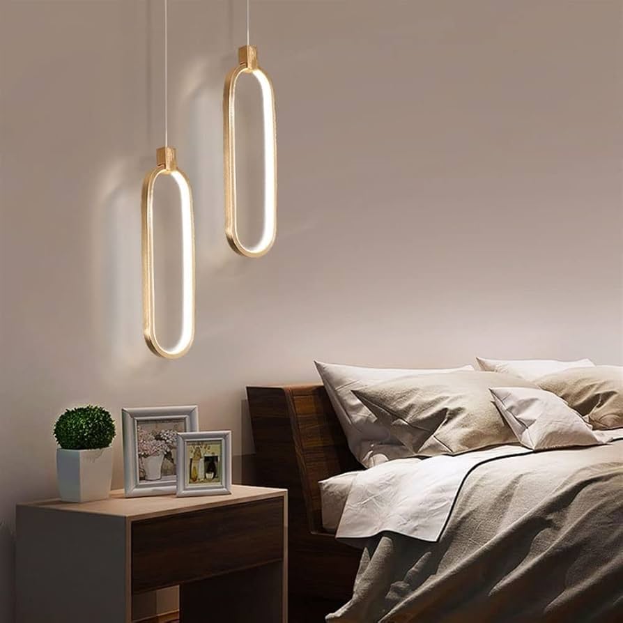 Modern bedroom with pendant lights, bed, nightstand, and decorative items.