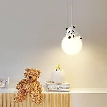 Panda-shaped lampshade on a shelf with a teddy bear and books