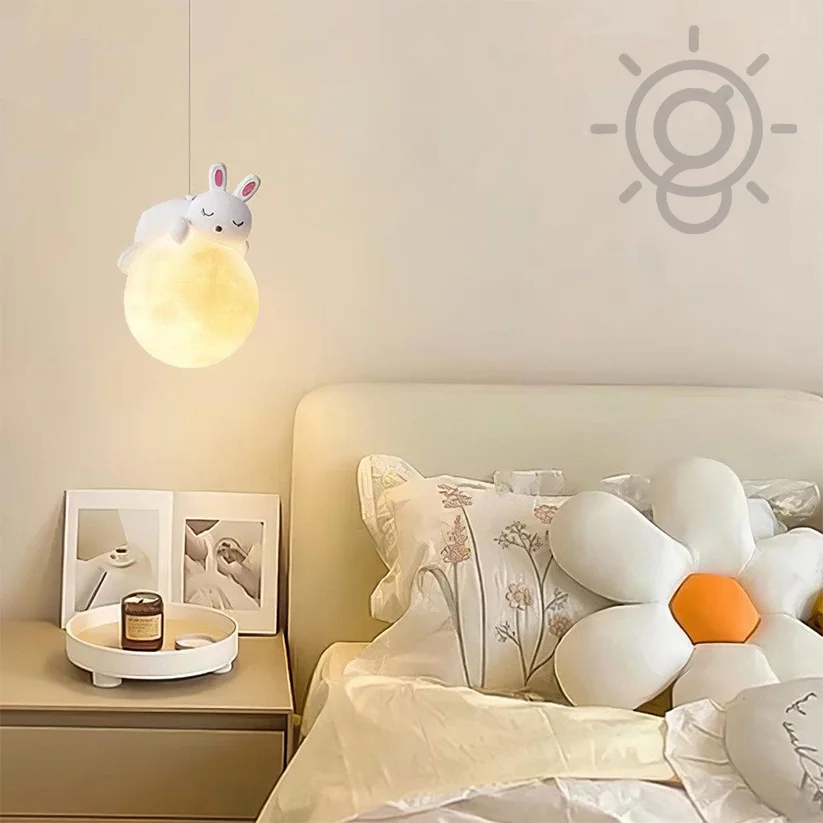 Children's room with a night light shaped like a cartoon character, a bed with floral pillows, and a nightstand with a candle.