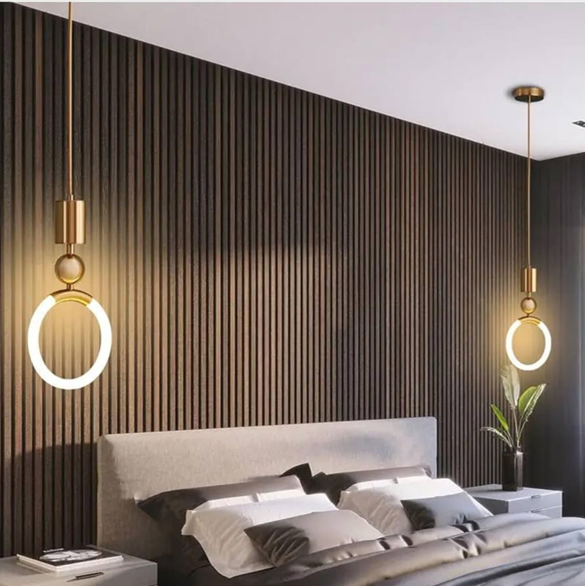 Modern bedroom with a bed, decorative pillows, and two gold pendant lights on a striped wall.