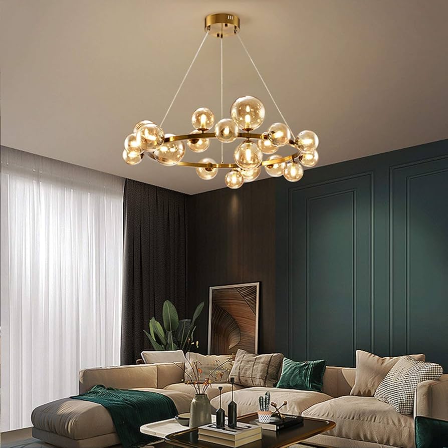 Modern living room with a gold chandelier, beige sofa, and decorative items.