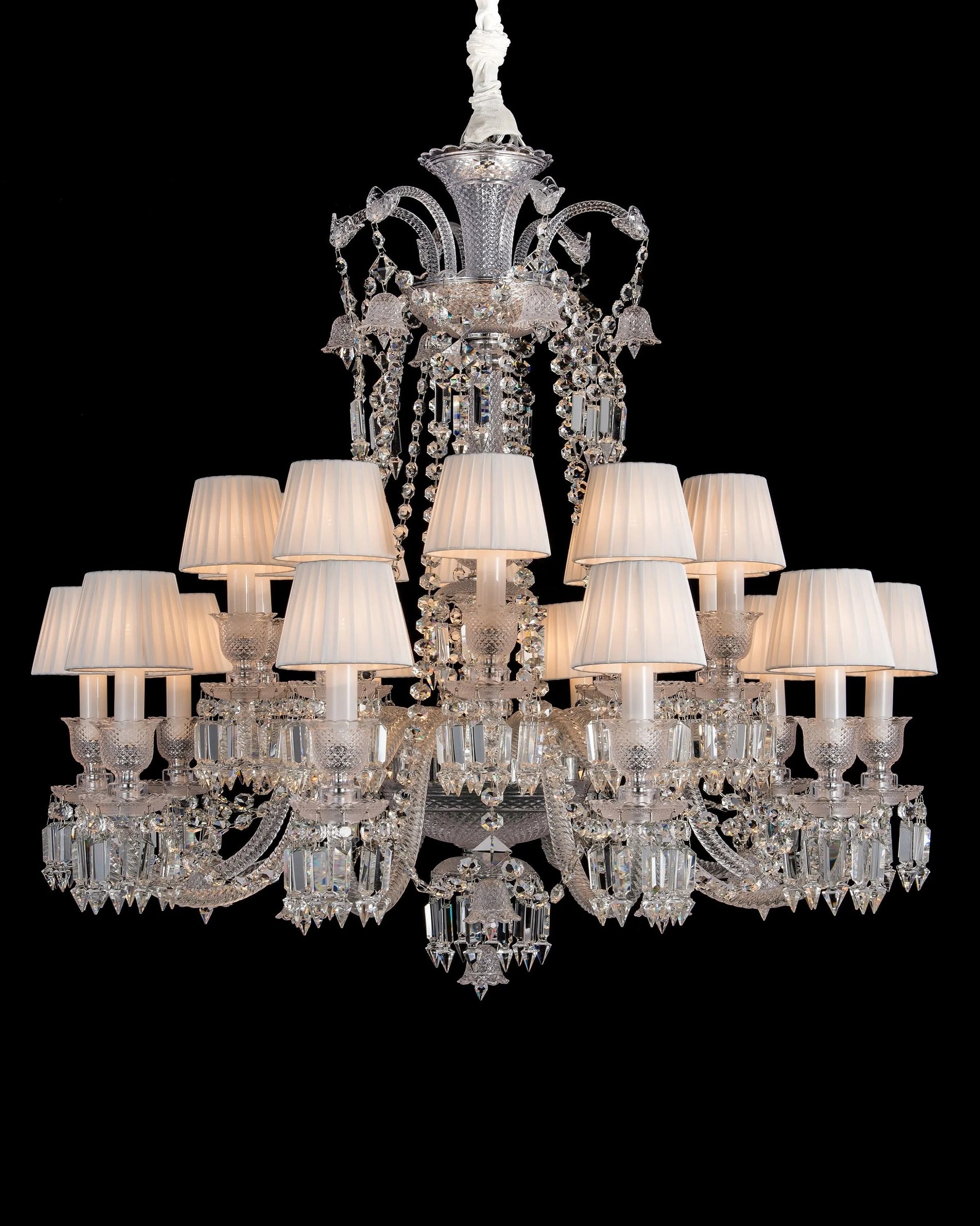 Luxury crystal chandelier with white lampshades on a black background