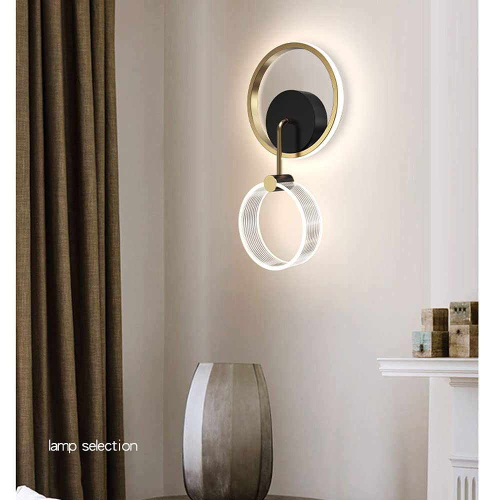 Modern wall lamp with gold and black design on a neutral wall.