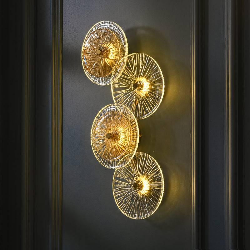Decorative wall light fixture with gold circular design on a dark background