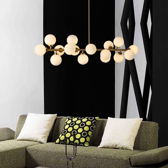 Modern living room with a chandelier, sofa, and decorative pillows.