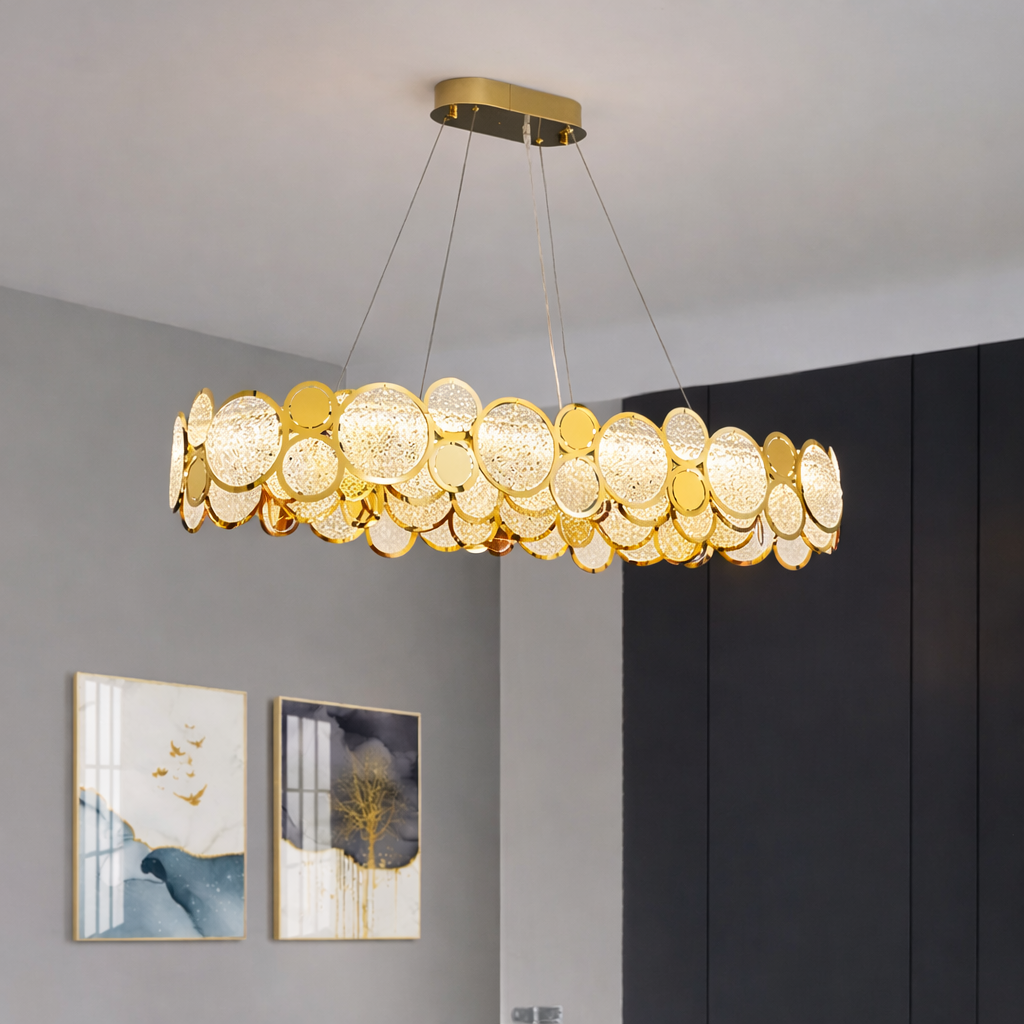 Gold chandelier hanging in a room with gray walls and framed pictures.