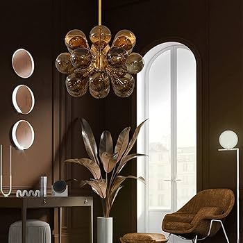 Modern interior design with a chandelier, plant, and armchair in a room with large windows.