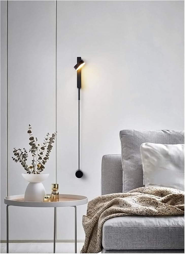 Modern interior with a gray sofa, side table, and wall-mounted lamp.