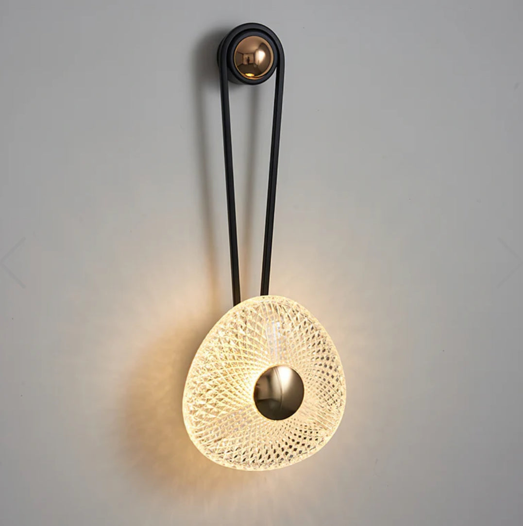 Decorative wall light fixture with textured design on a plain background
