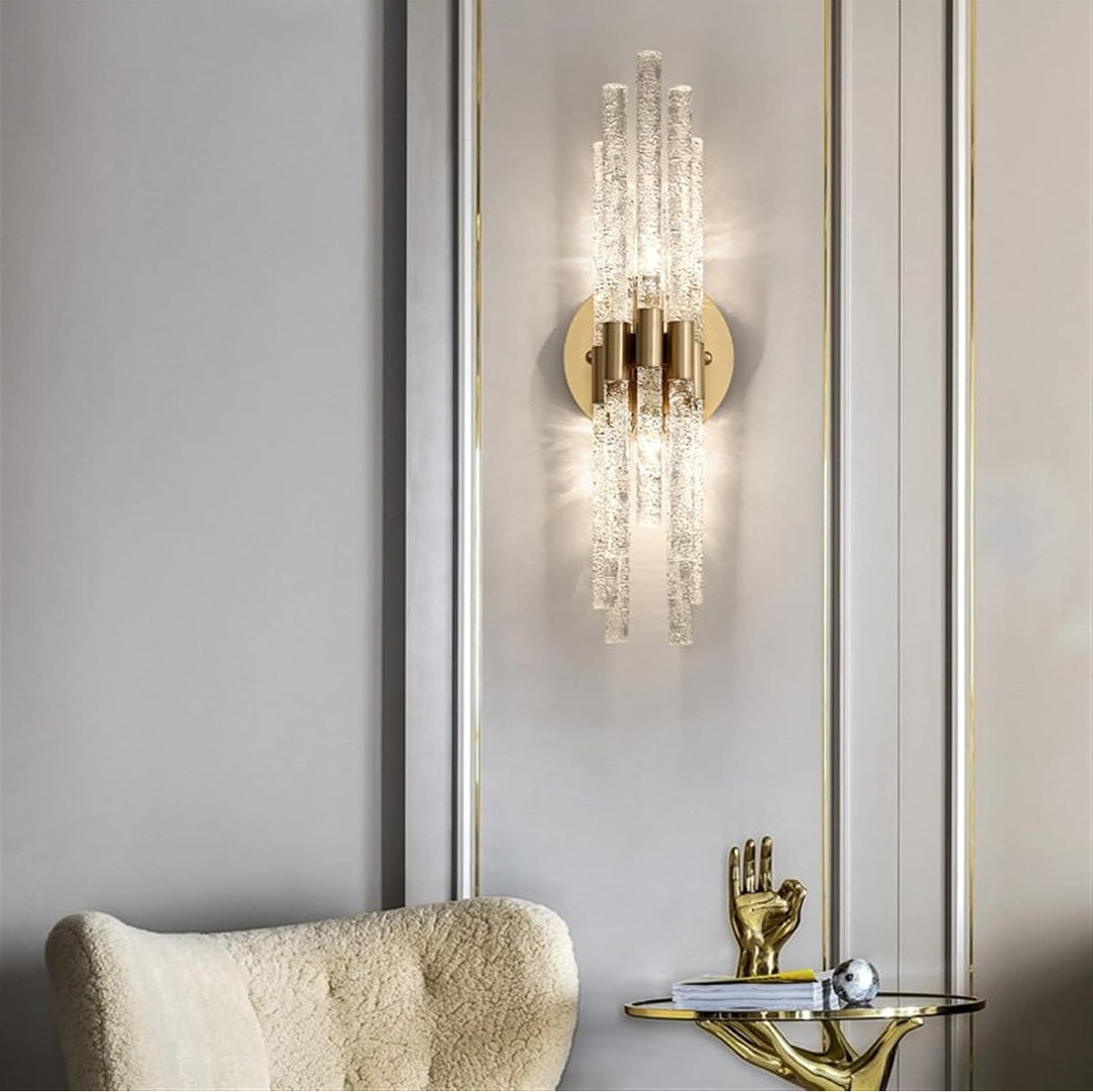 Decorative wall sconce with crystal design on a gray wall, next to a textured chair and small table.
